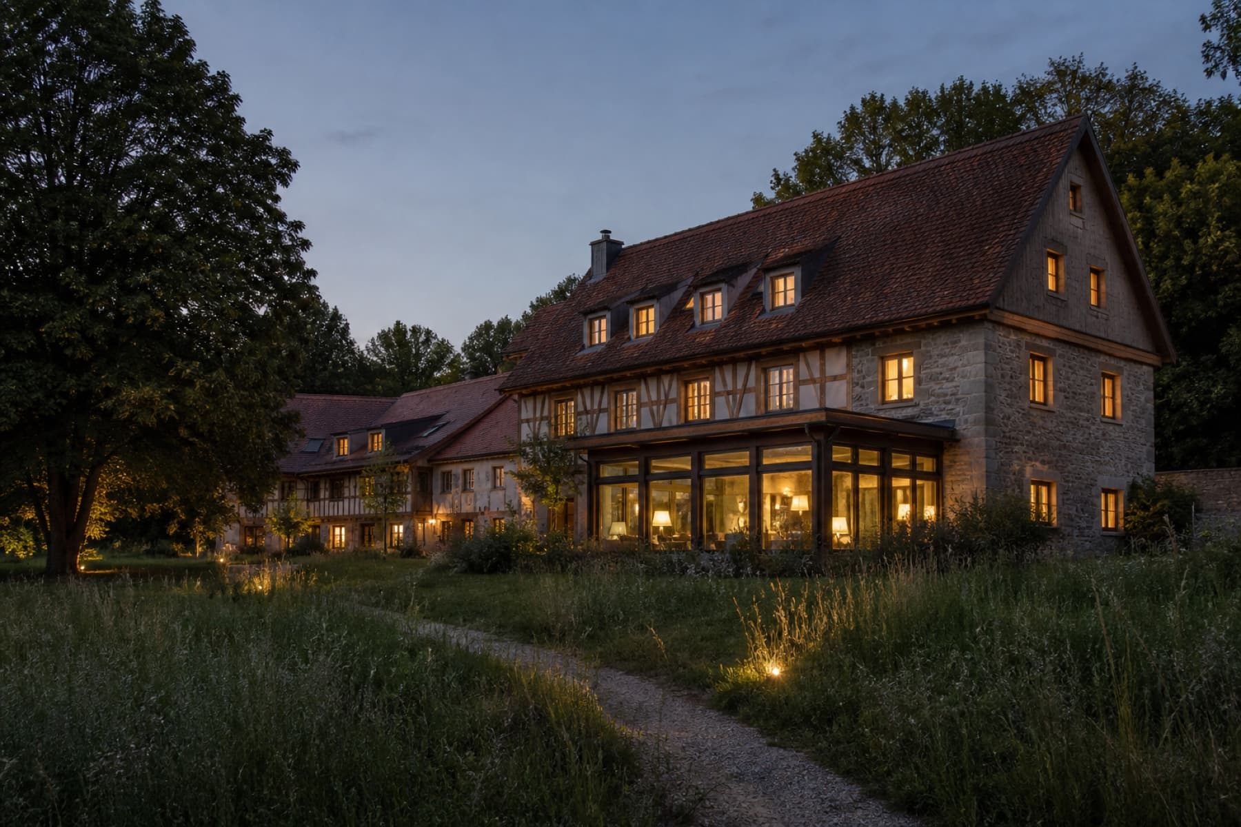 Stimmungsvoll beleuchtetes Landhotel in einem grünen Garten
